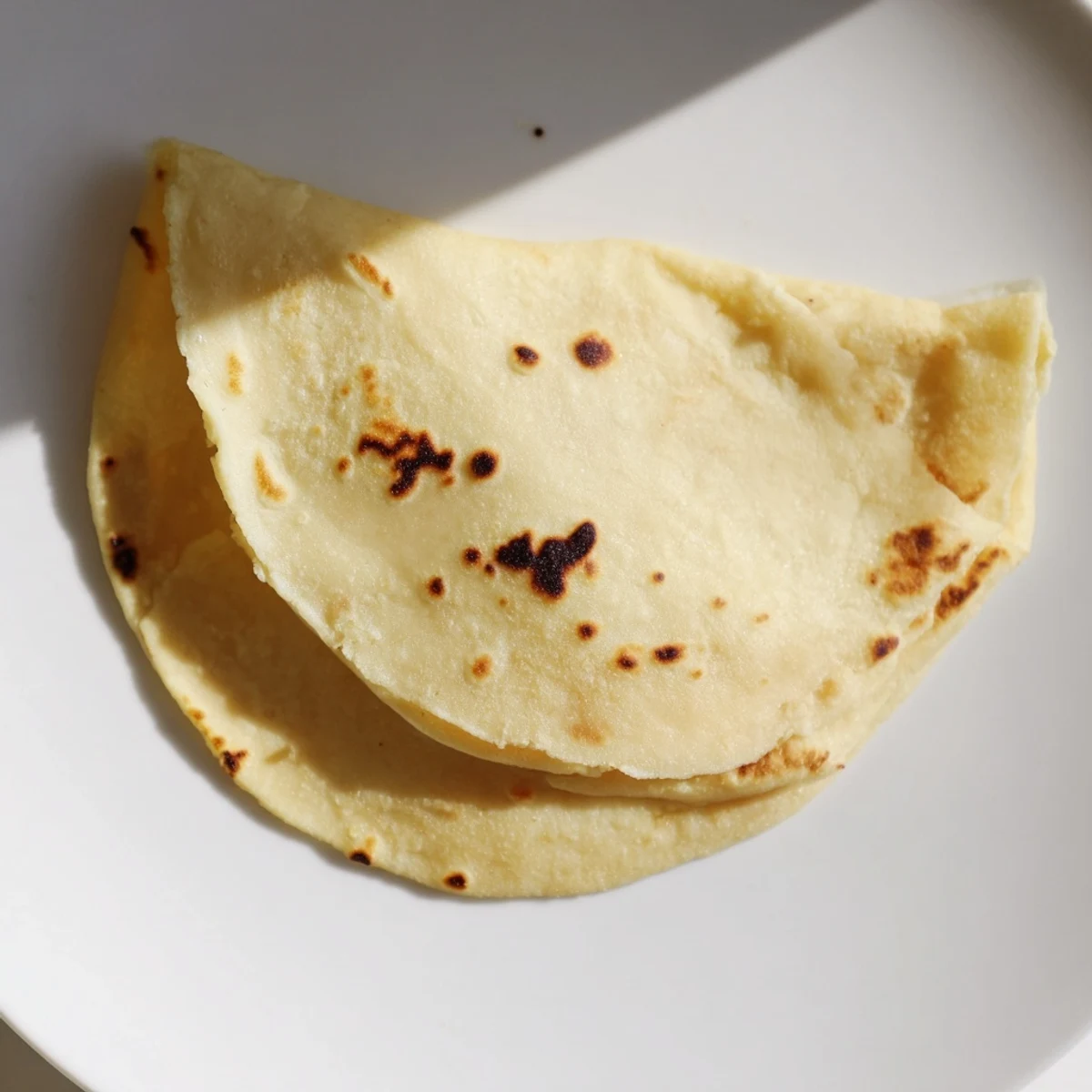 Freshly cooked gluten-free sweet potato cassava tortillas steaming on a plate, perfect for wrapping your favorite taco fillings