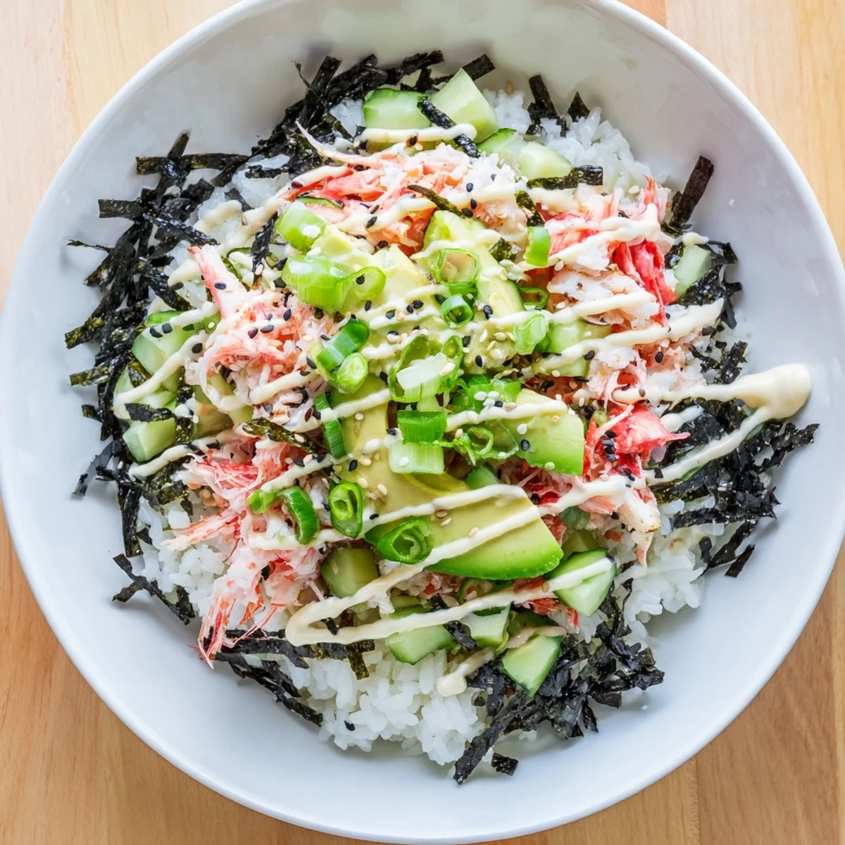 California Roll sushi bowls topped with shredded crab, fresh avocado, cucumber and nori strips
