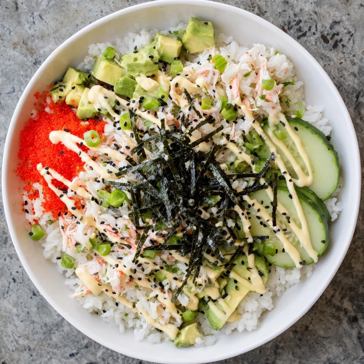 Homemade California roll sushi bowl arranged with colorful toppings over seasoned white rice