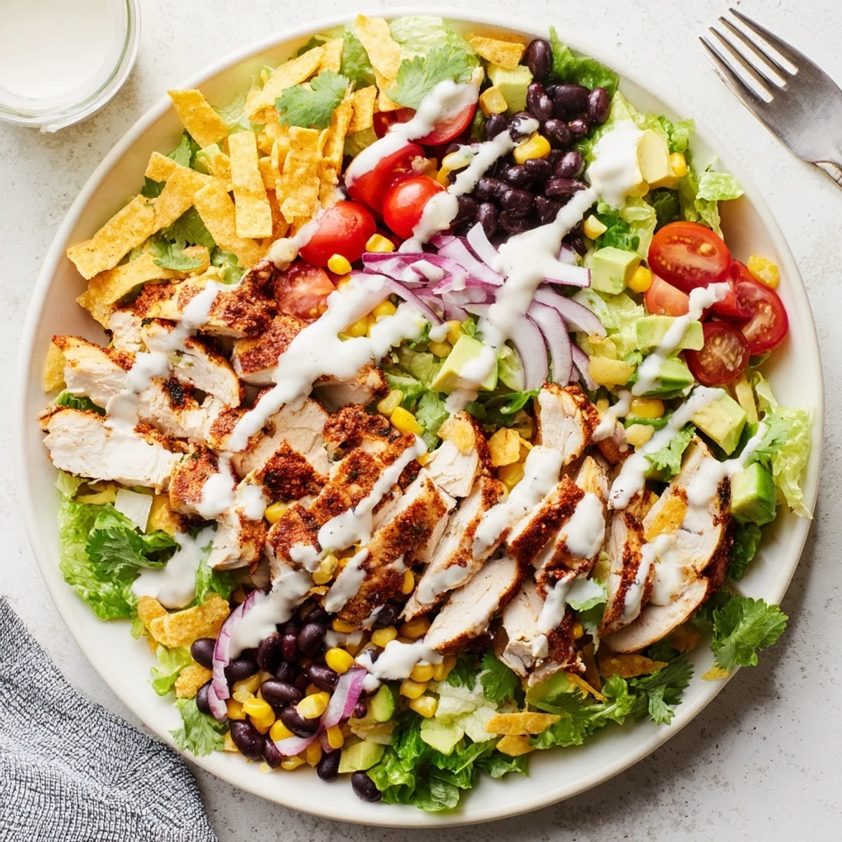 Colorful southwestern chicken salad bowl with grilled chicken, avocado, corn, black beans, and zesty lime dressing