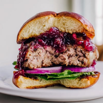 Freshly simmered cranberry topping and crisp lettuce add vibrant color to this gourmet poultry burger.