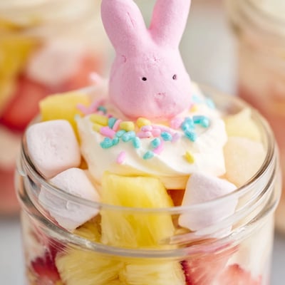Strawberry and lemon gelatin cubes mixed with fresh fruit and fluffy cream cheese filling inside a 6-ounce serving jar.