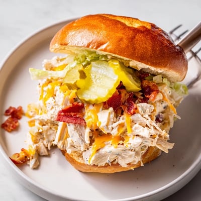 Creamy Crack Chicken Sandwiches spooned hot onto brioche buns, pickles optional